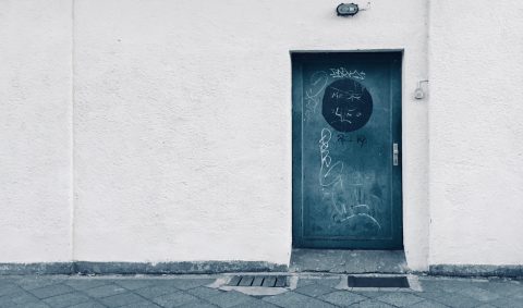 Öde Fassade ohne Fenster mit abweisender Metalltür